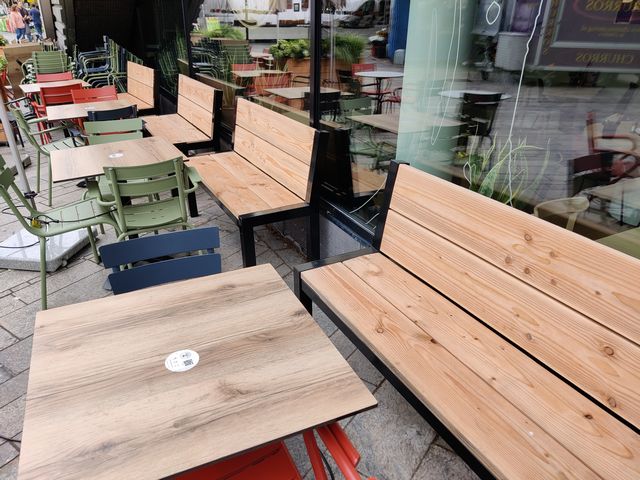 Houten horecabanken met zwart stalen frame op een horecaterras
