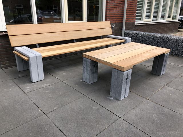 Houten tuinbank en tuintafel met robuuste betonnen poten op een terras