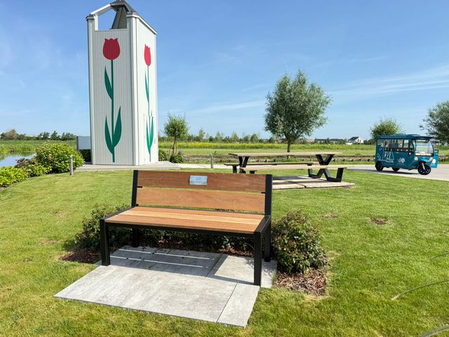 Houten parkbank met stalen frame geplaatst op een vakantiepark