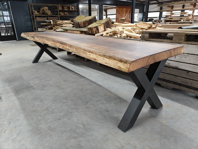 Massieve houten boomstamtafel met natuurlijke boomrand en zwarte stalen X poten