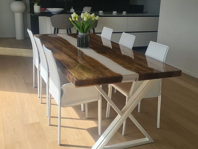 Houten epoxy eettafel met witte epoxy rivier en wit stalen onderstel in een modern interieur