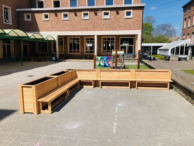 Maatwerk houten zitbanken met plantenbakken op een schoolplein