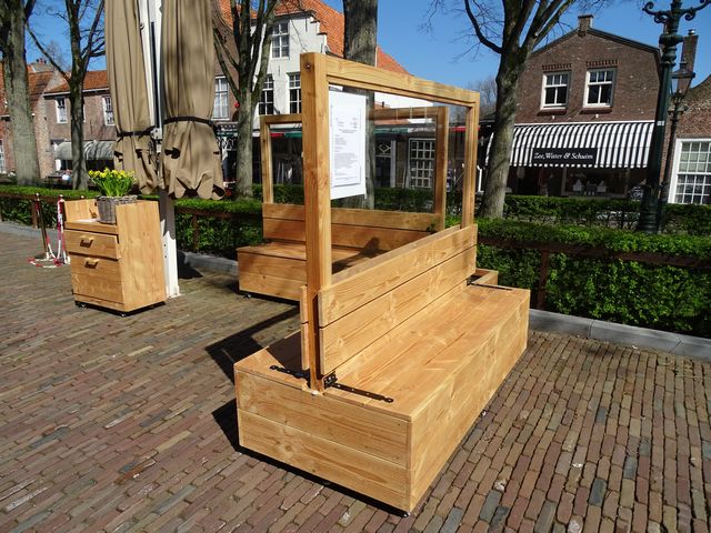 Maatwerk houten terrasafscheiding met zitbank en glazen terrasschermen voor een horecaterras