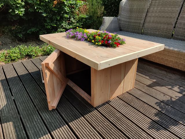 Maatwerk houten tuintafel met plantenbak en opbergruimte op een terras