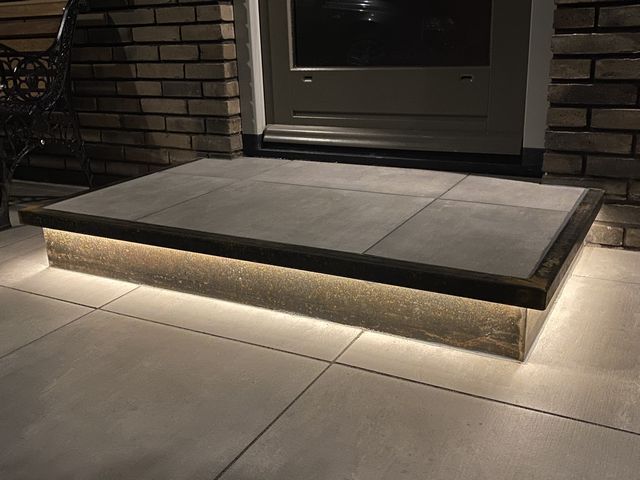 Cortenstalen traptrede op maat met geïntegreerde ledverlichting bij een entree
