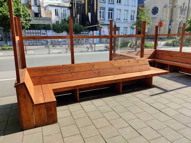 Houten terrasafscheiding met lexaan windscherm en geïntegreerde houten zitbank