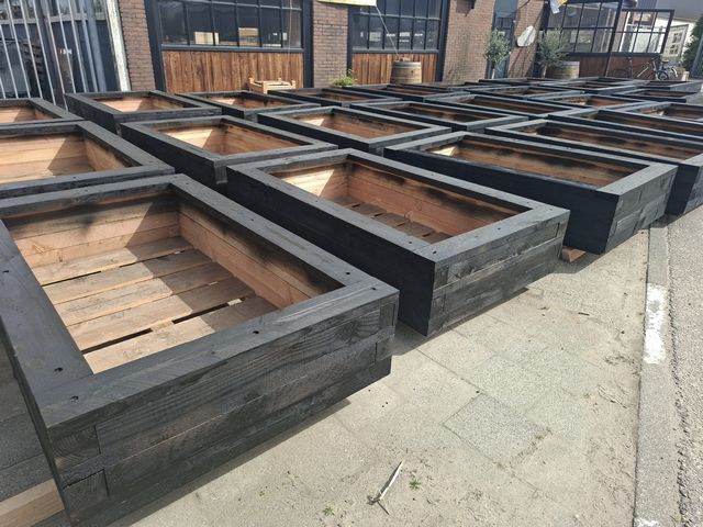 Serie houten plantenbakken in productie op het buitenterrein van de werkplaats van Tuinwaardig